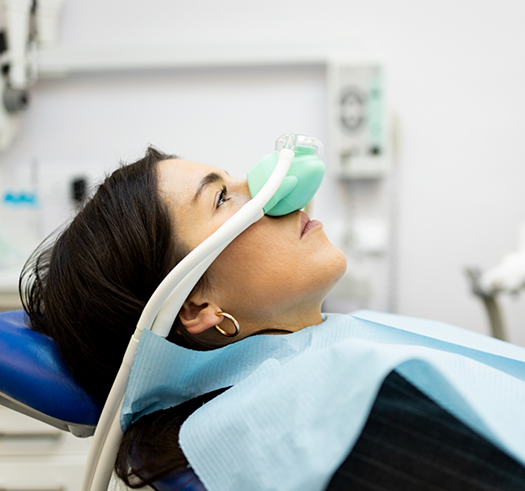 Woman in the dental chair with a nitrous oxide mask over her nose