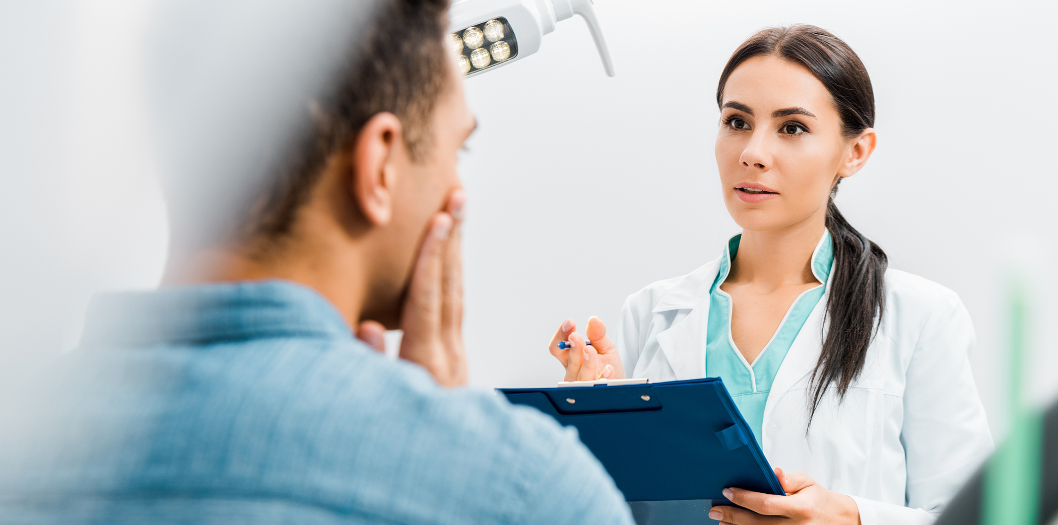 Emergency dentist in Bartlett holding a clipboard and listening to a patient