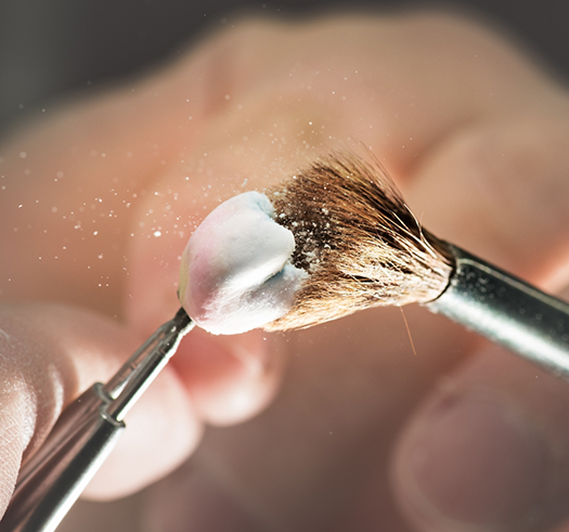 Close up of a small brush dusting off a dental crown