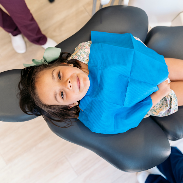 Young girl in the dental chair looking up toward the camera