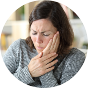 Woman holding the side of her face and wincing in pain