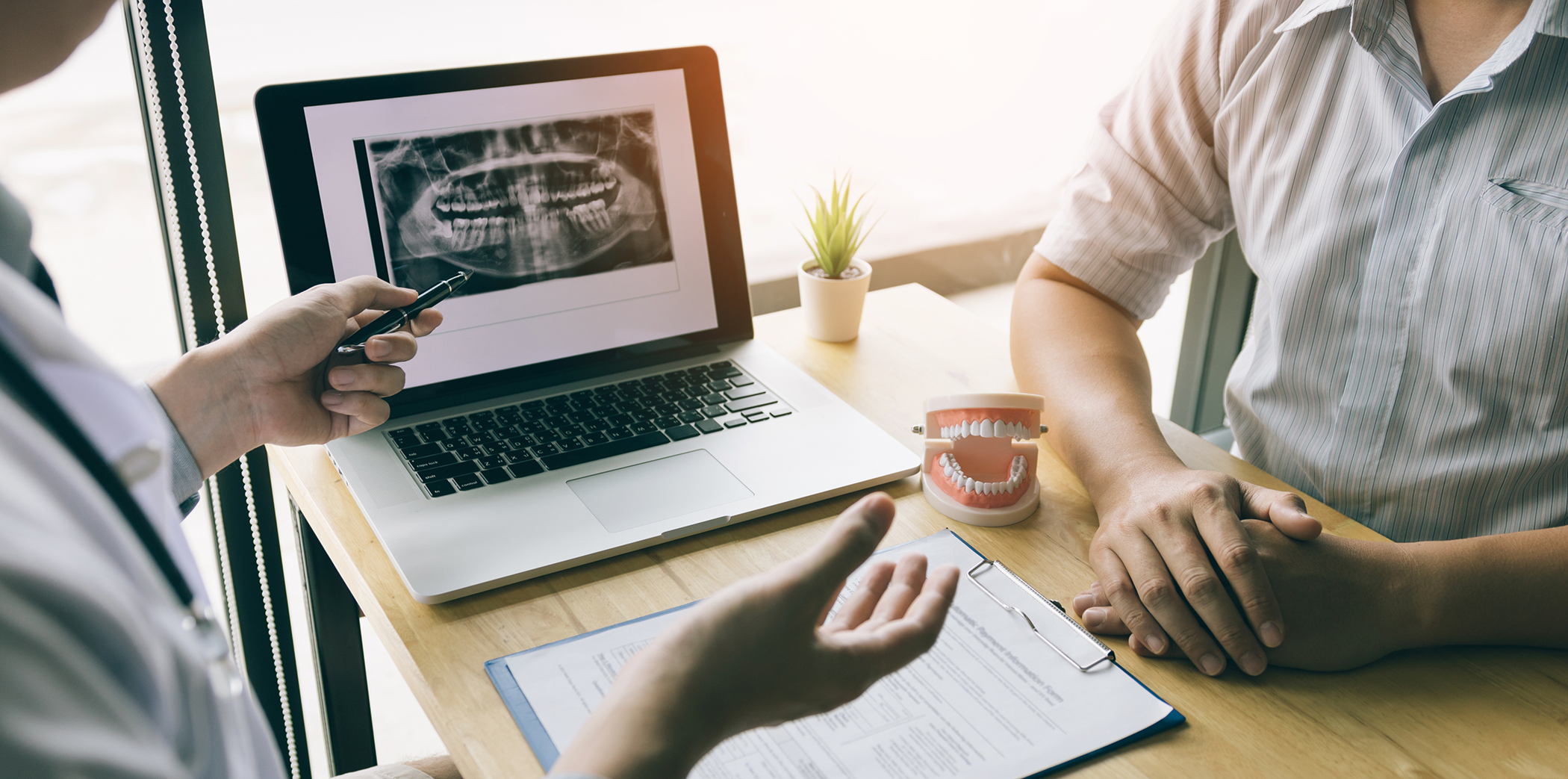Patient sitting across a table from their Bartlett dentist during a consultation