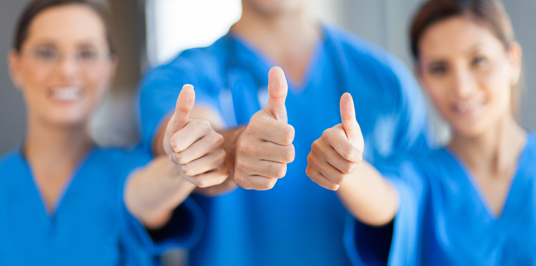 Three Bartlett dental team members smiling and giving thumbs up