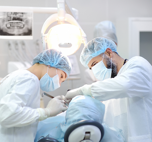 Dentist and assistant performing a dental procedure on a patient