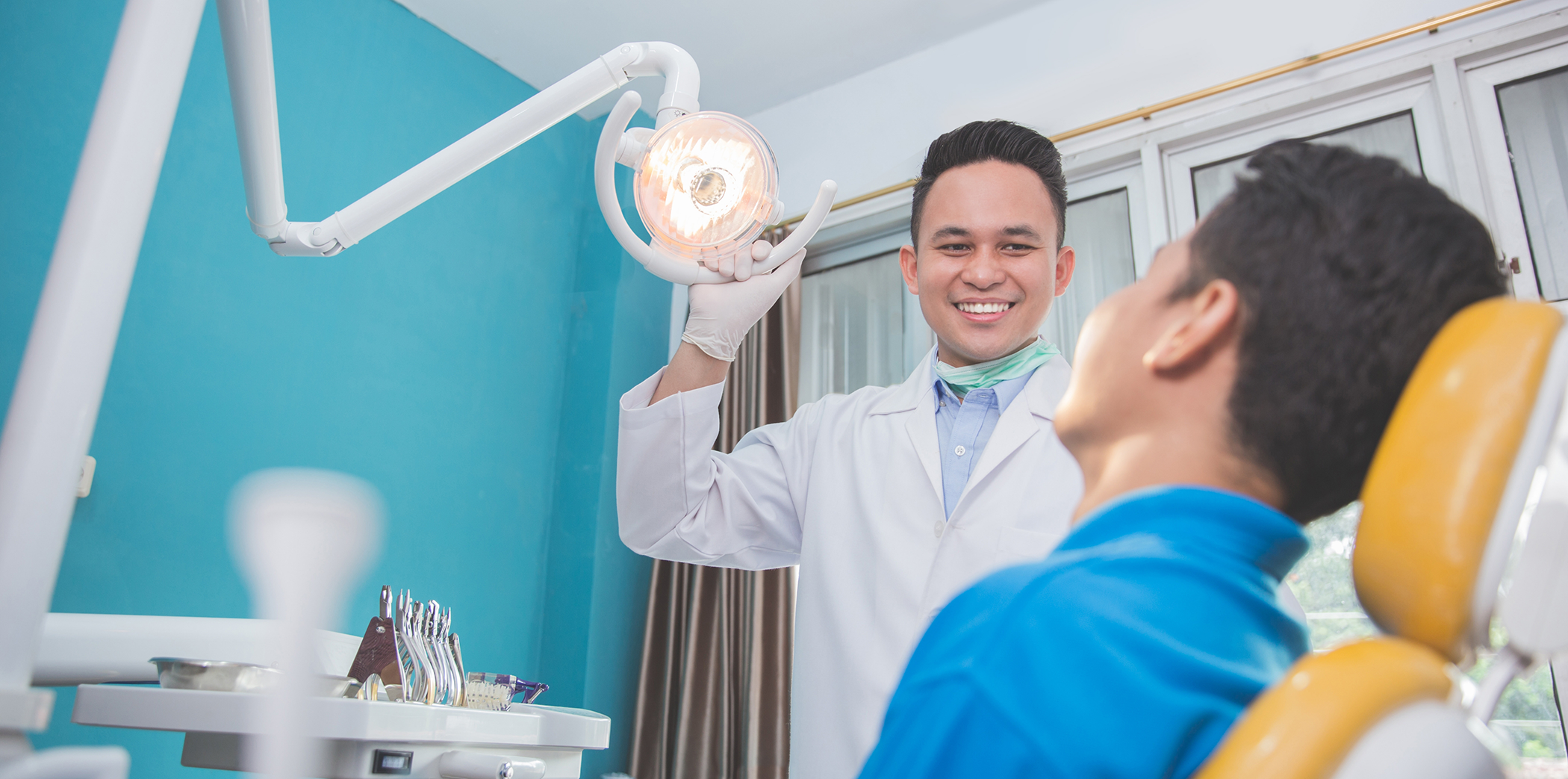Dentist smiling at a patient in the dental chair