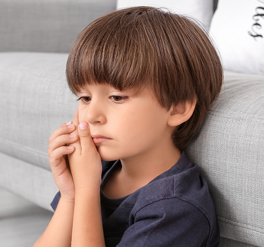 Young boy holding the side of his face in pain