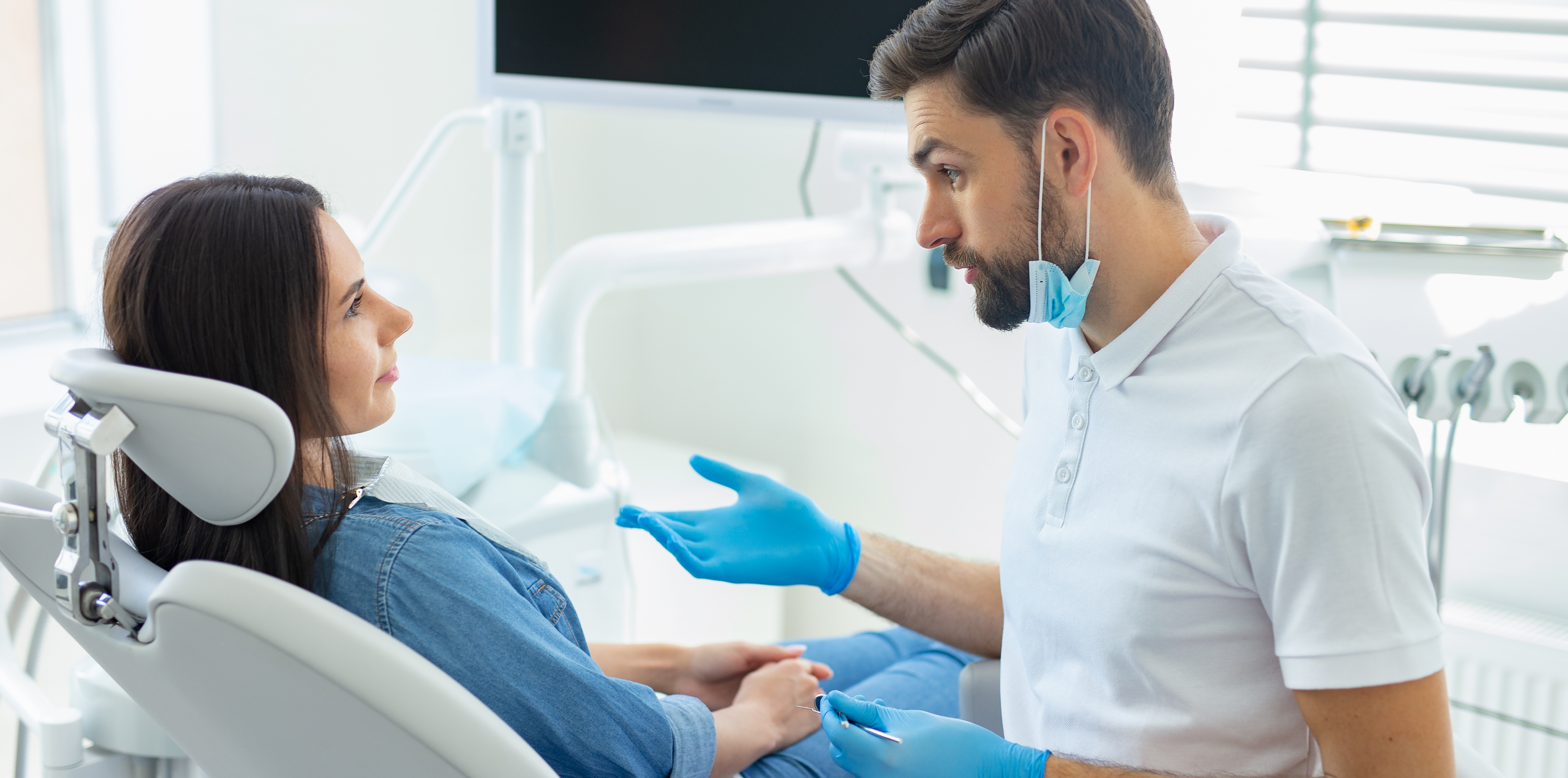 Bartlett periodontist talking to a patient in the treatment chair