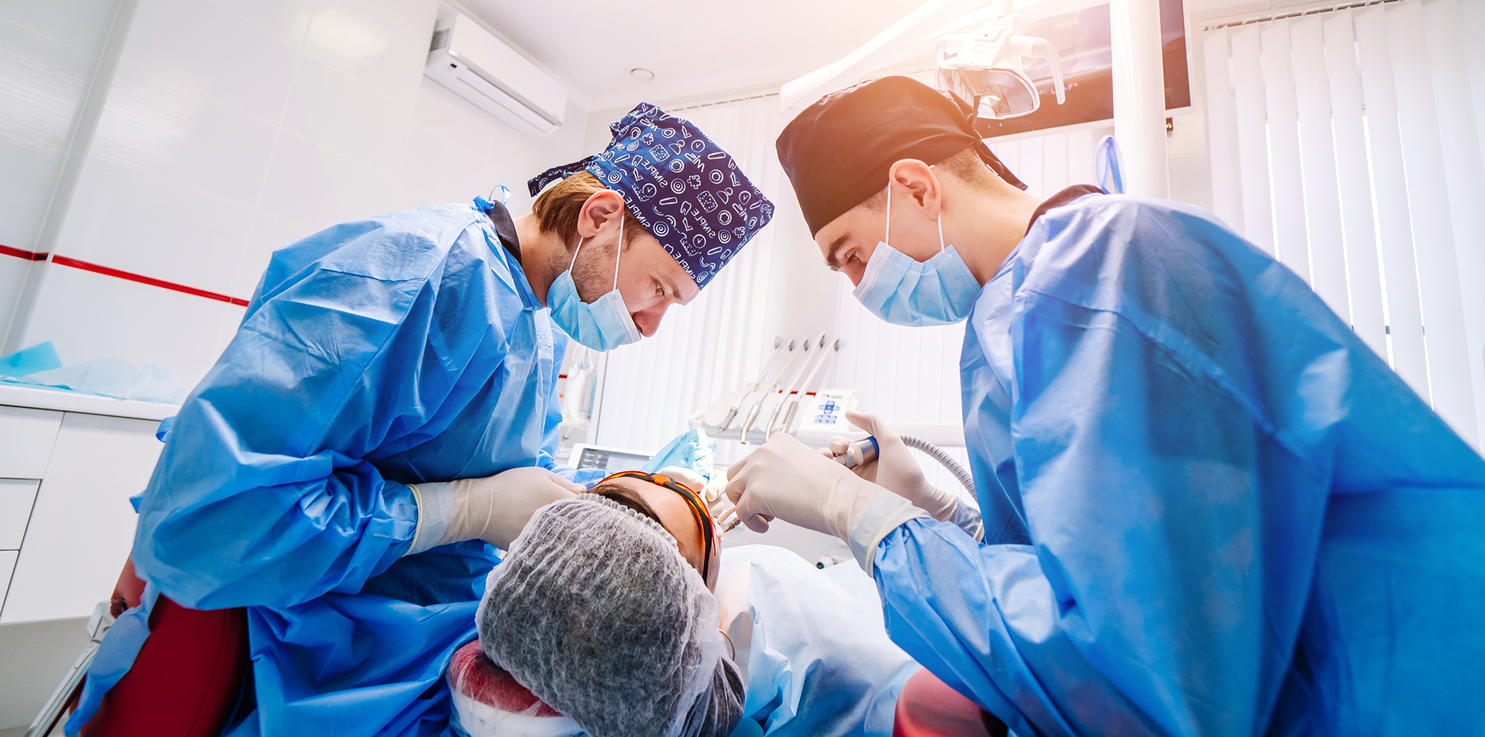 Dentist and assistant performing tooth extractions on a Bartlett dental patient